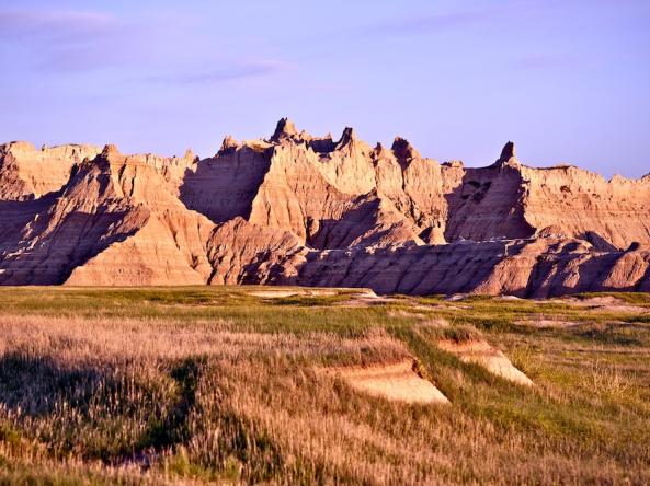 Badlands rock formation with drying grass