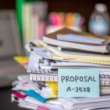 A stack of notebooks and documents, representing policy documents. Photo credit: Shutterstock, Eiko Tsuchiya.