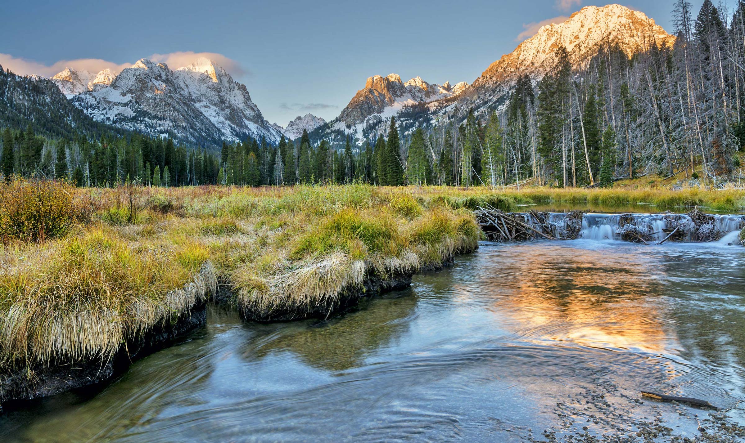 Sunrise in the Idaho mountains with a lake and a beaver dam.