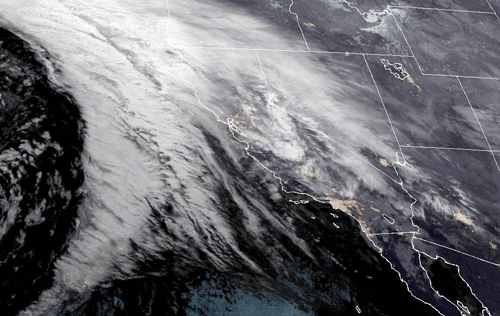 An animated gif of NOAA GOES-West satellite imagery from January 4th, 2023. Clouds are shown in white. An atmospheric river can be seen funneling moisture over the coast of OR, WA, and Northern CA.