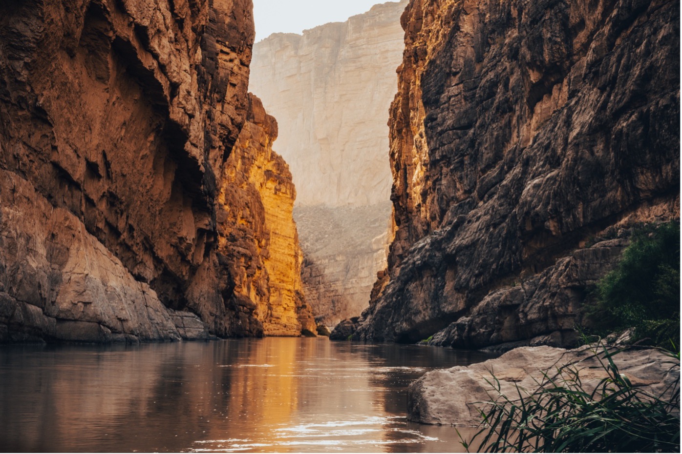 Water surrounded by tall rock formations. The Rio Grande River runs through Santa Elena Canyon in Big Bend National Park.