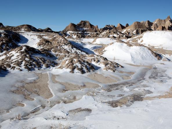 Melting and patchy snow on hills and mountains in the Badlands. Photo credit: dschreiber29, Adobe Stock.