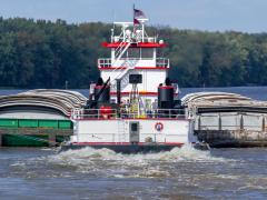 A barge on a river represents the navigation & transportation sector.