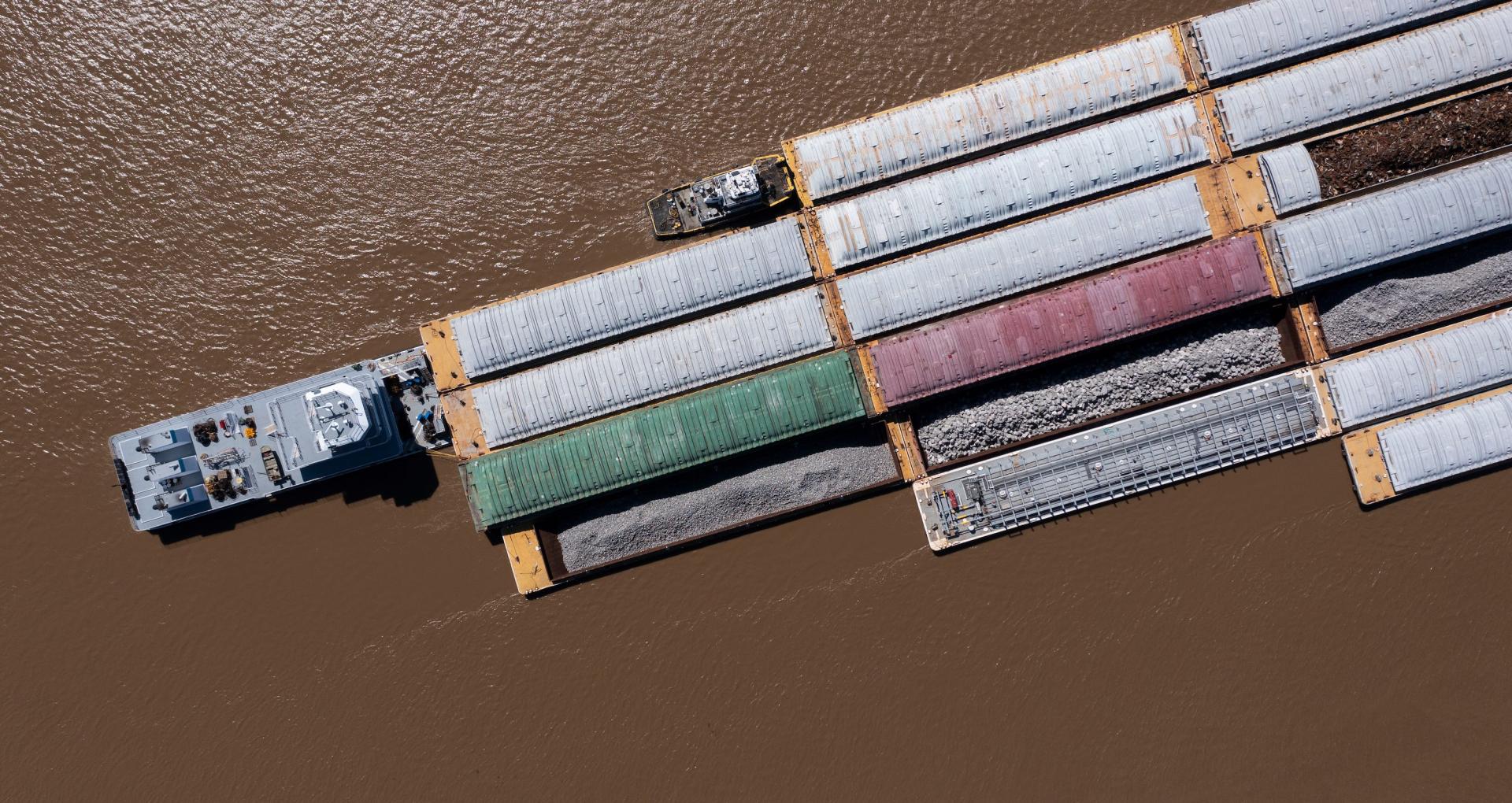 A towboat, known as a pusher, pushes barges full of cargo up the Mississippi River near downtown Baton Rouge, Louisiana. Photo credit: Matt Gush, Adobe Stock.