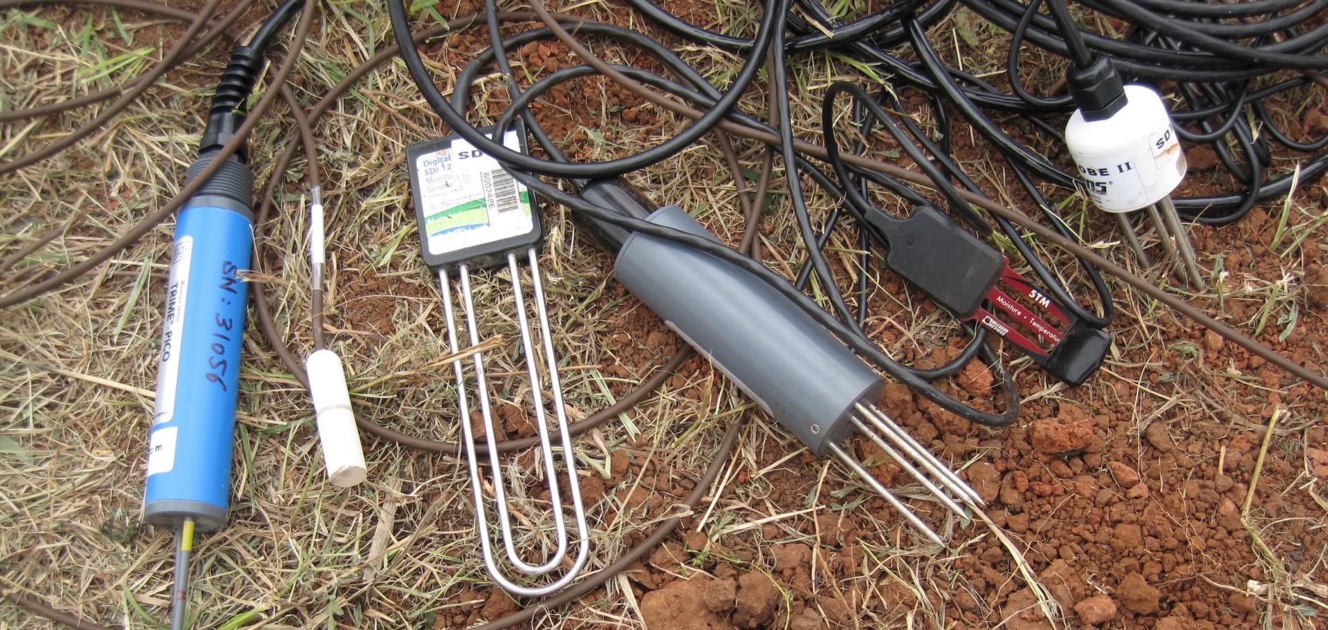 Different types of soil moisture probes laid side by side on the ground. Photo credit: Tyson Ochsner.