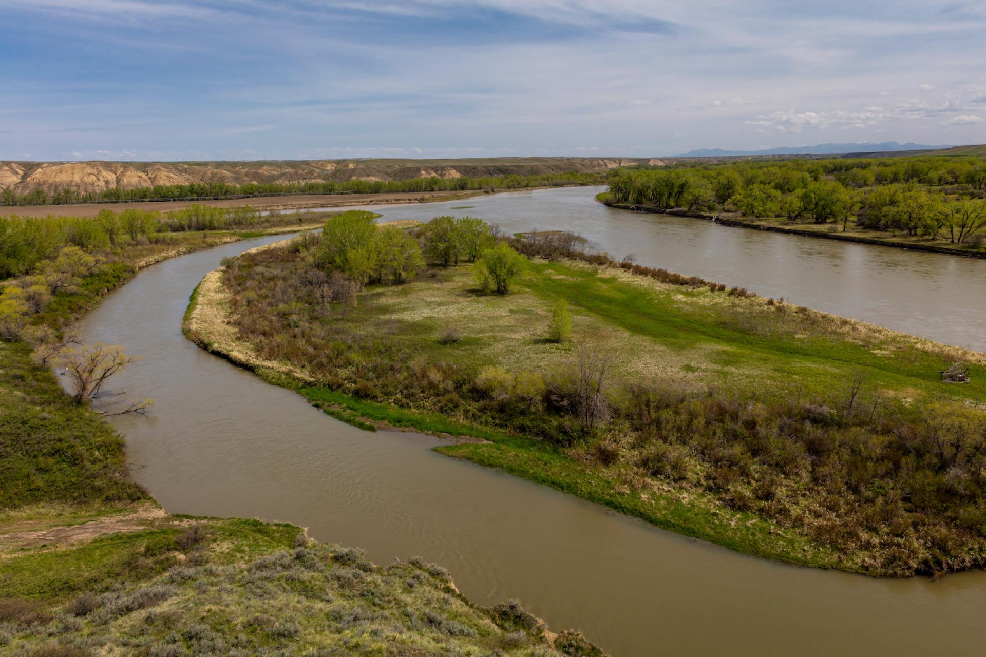 The Missouri River surrounded by grass and shrubs, at the confluence of the Marias and Missouri River. Photo credit: spiritofamerica, Adobe Stock.