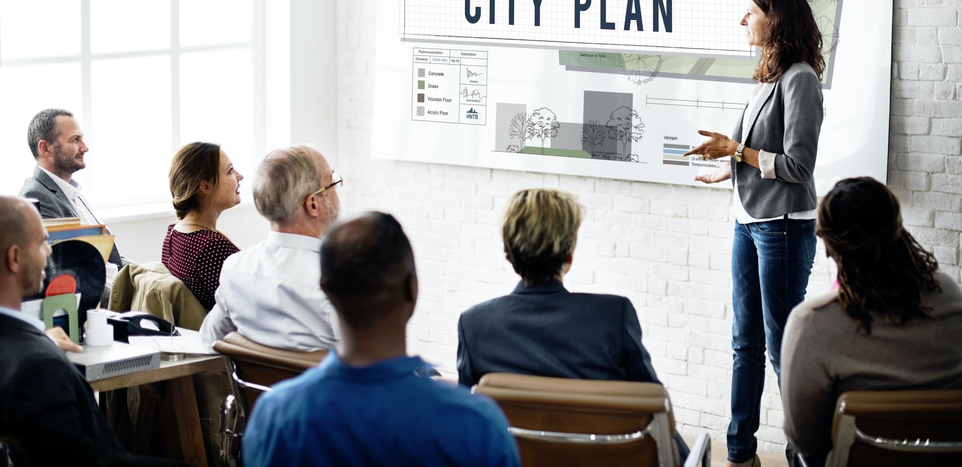 A group of people at a planning meeting represents the process of planning for hazards like drought.