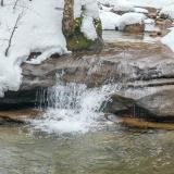 Runoff from melting snow flowing into a stream, representing snow drought.
