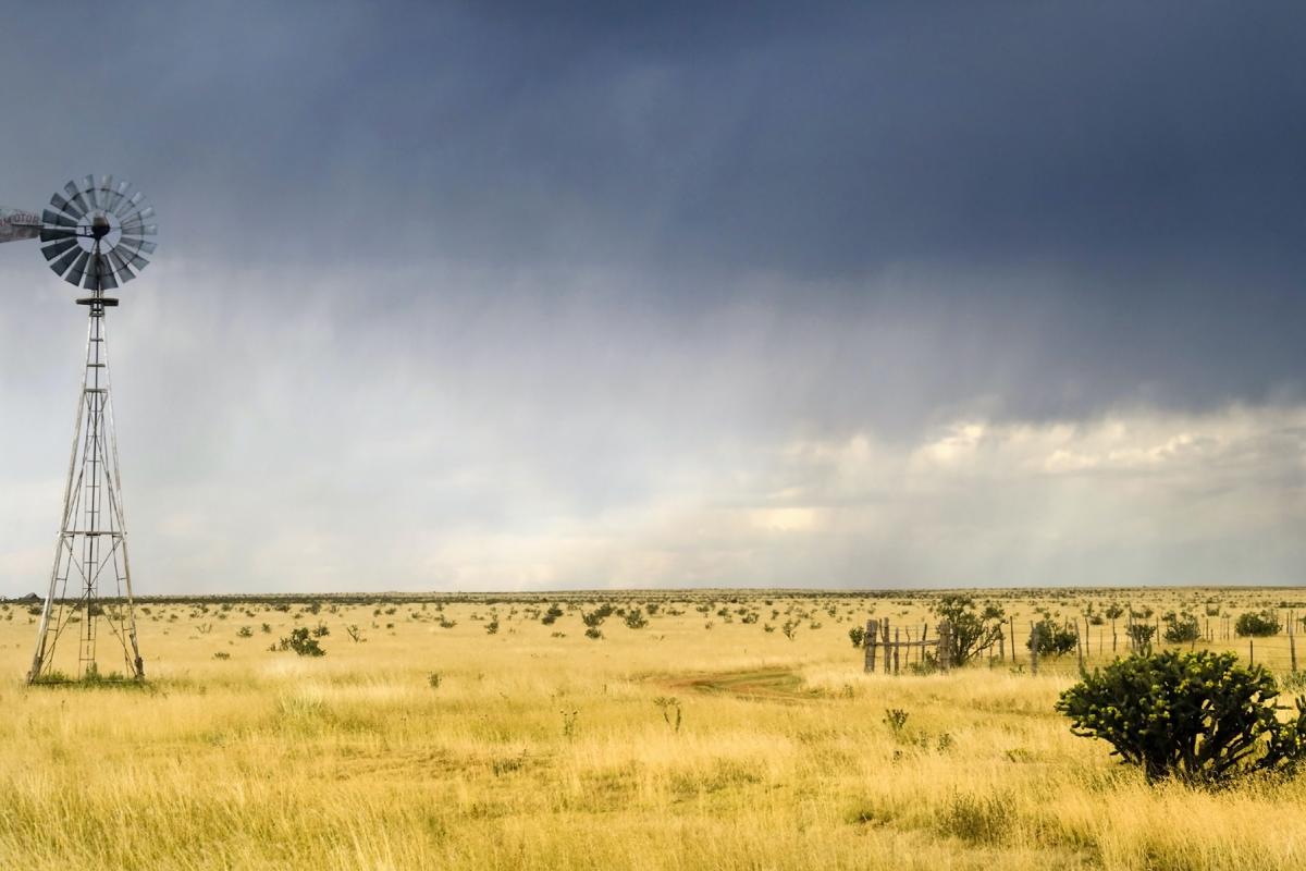 Windmill in a Texas field with a storm approaching