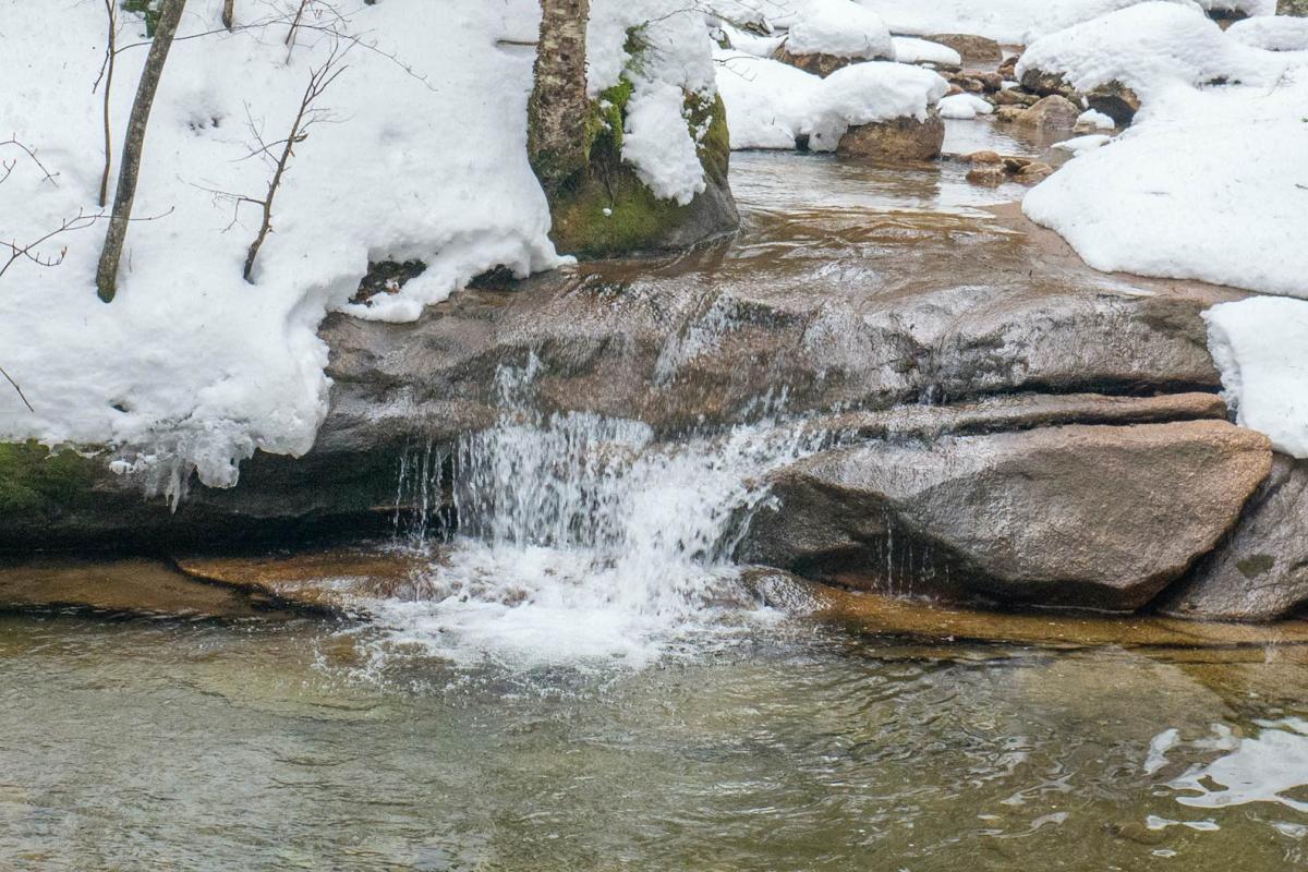 Runoff from melting snow flowing into a stream, representing snow drought.